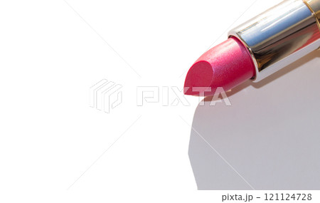 Close-up of a part of a gold lipstick tube on a white background with a copy of the space on the left 121124728