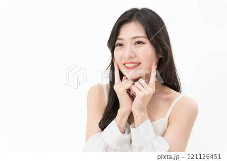 頬に指差ししている若い女性 ビューティー・デンタルケア 頬に指差ししている若い女性 ビューティー・デンタルケア 121126451
