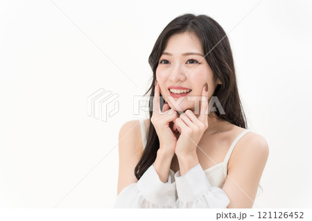 頬に指差ししている若い女性 ビューティー・デンタルケア 頬に指差ししている若い女性 ビューティー・デンタルケア 121126452