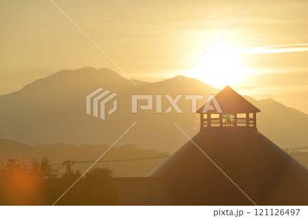 北杜市白州町、茅ヶ岳から昇る朝日が道の駅はくしゅうの三角屋根を照らす 121126497