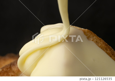 溶かしたチーズをバゲットにかける 溶かしたチーズをバゲットにかける 121126535