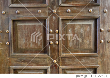 A old classic wooden door with a surface and decorative trim. A old classic wooden door with a surface and decorative trim. 121127394