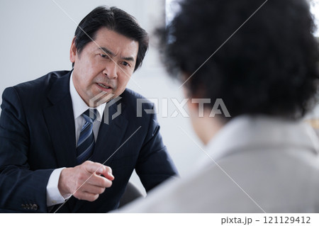 警察などの取り調べなど尋問や圧迫面接や会社のパワハラのイメージ　指差しで怒る 121129412