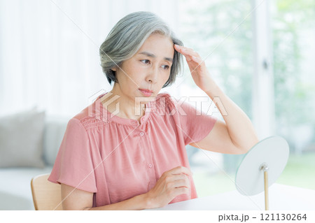 ヘアケアをするシニア女性 ヘアケアをするシニア女性 121130264