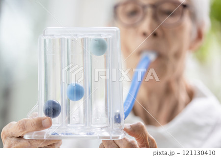 Asian senior woman using incentive spirometer,tool to help the lung expansion,exercise the lung,old elderly with chronic obstructive pulmonary disease,problem of respiratory system,health care,medical 121130410