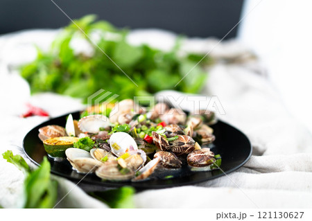 A vibrant platter of clams and mussels with garlic and herbs invites a seafood feast. 121130627
