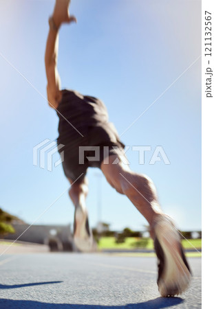 Athlete running on a sports track for fitness exercise in outdoor training practice. Below view of fit active man sprinting motion blur speed. Runner performing cardio workout for health and stamina 121132567