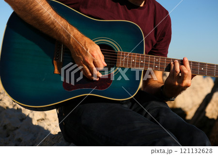 Close-up of a man's hands playing acoustic guitar Close-up of a man's hands playing acoustic guitar 121132628