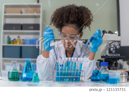Scientist mixing chemical liquids in the chemistry lab. Researcher working in the chemical laboratory. 121135731