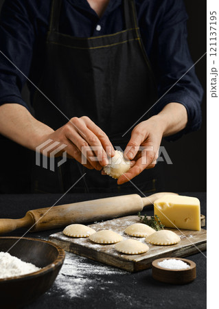 Preparing homemade ravioli with fresh ingredients in a kitchen setting 121137195
