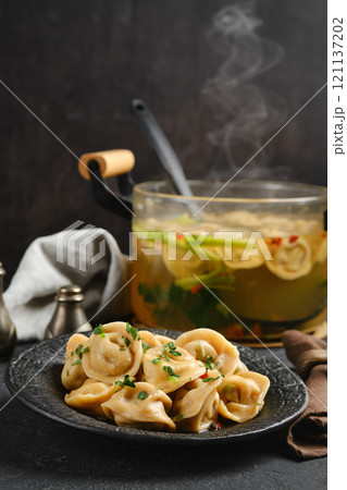 Delicious dumplings served with flavorful broth in a cozy kitchen setting Delicious dumplings served with flavorful broth in a cozy kitchen setting 121137202