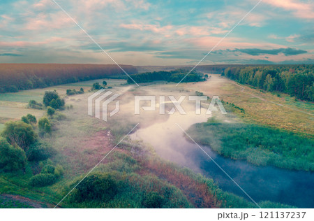 Aerial view of countryside and river in early misty morning. Trees along river. The time before sunrise. View from above Aerial view of countryside and river in early misty morning. Trees along river. The time before sunrise. View from above 121137237