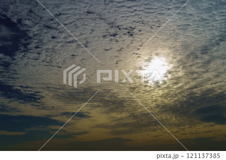 うろこ雲の上に昇る太陽 121137385