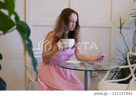Happy young woman relax on comfortable couch at home texting messaging on smartphone, smiling girl use cellphone chatting, browse wireless internet on gadget, shopping online from home 121137842