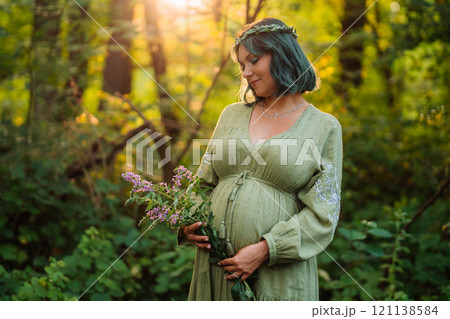 Portrait Of Fairy Pregnant Woman In Wild Forest At Sunset, Golden Hour Portrait Of Fairy Pregnant Woman In Wild Forest At Sunset, Golden Hour 121138584