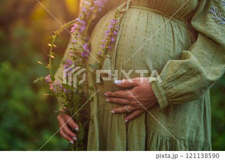 Hands of fairy Pregnant Woman In Wild Forest At Sunset, Golden Hour. Beauty of female body Hands of fairy Pregnant Woman In Wild Forest At Sunset, Golden Hour. Beauty of female body 121138590