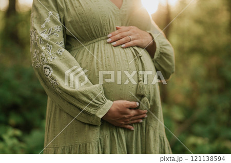 Hands of fairy Pregnant Woman In Wild Forest At Sunset, Golden Hour. Beauty of female body Hands of fairy Pregnant Woman In Wild Forest At Sunset, Golden Hour. Beauty of female body 121138594