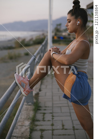 An Active Woman Engaged in Stretching Exercises Outdoors to Enhance Her Fitness Level 121138864