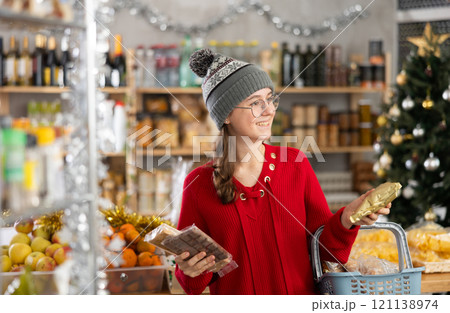 Adolescence girl customer choose consider desserts and sweet snacks. Adolescence girl customer choose consider desserts and sweet snacks. 121138974