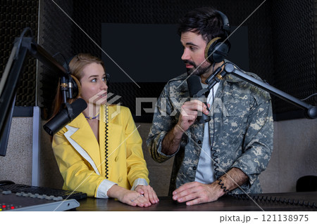 Man and woman presenting in radio station hosting live radio show 121138975