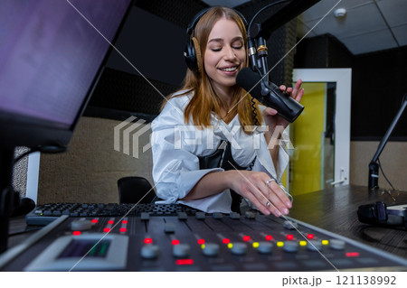 Woman radio host mixing audio at radio station live show 121138992