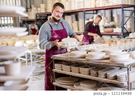 Young man posing with ceramic blanks 121139499