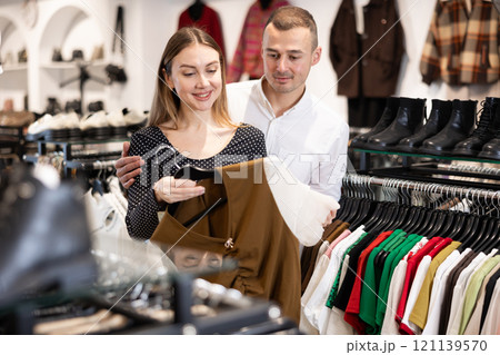Couple young woman and young man choosing blouse Couple young woman and young man choosing blouse 121139570