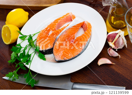 Fresh steaks of salmon on white plate with seasonings prepared for roasting 121139599