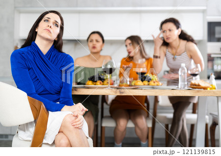 Portrait of an upset brunette woman who quarreled with her friends at party 121139815