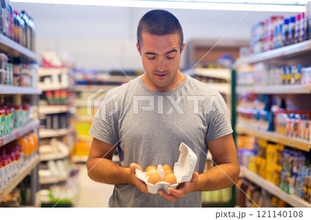 Man choosing eggs in supermarket 121140108