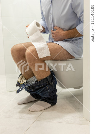 Man sitting in a toilet and having problems with digestion 121140109