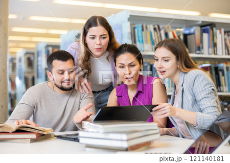 Group of students learning together at library 121140181