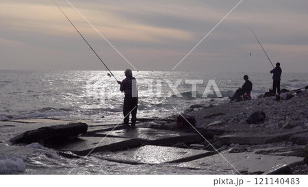 Many fishermen catch mullet fish on a spinning rod on the sea coast Many fishermen catch mullet fish on a spinning rod on the sea coast 121140483