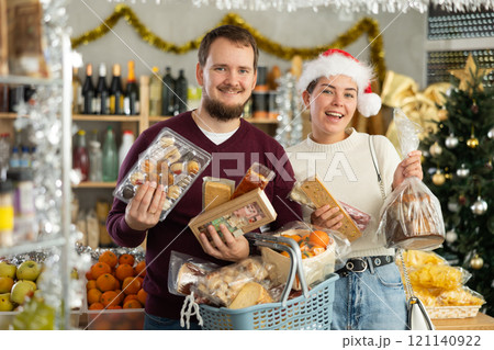 Preparing for Christmas celebration - happy family buys nougat, panettone, marzipan, panellets 121140922