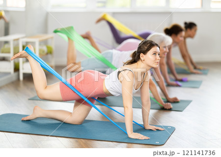 Young woman exercising with pilates band 121141736