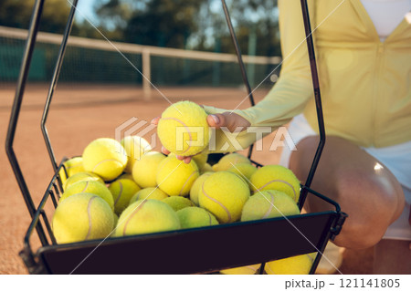 Close up of a basket with yellow tennis balls 121141805