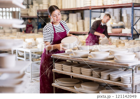 Young woman posing with ceramic blanks 121142049