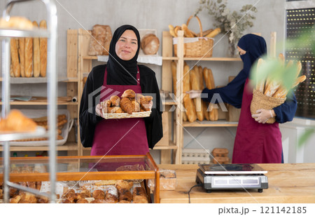 Hospitable saleswoman presenting traditional pastries in Muslim bakery 121142185