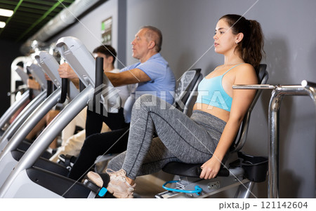 Woman warming up on bikes in spin class at gym 121142604