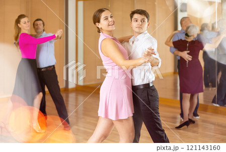 Young girl learning to dance waltz with guy in dancing class Young girl learning to dance waltz with guy in dancing class 121143160