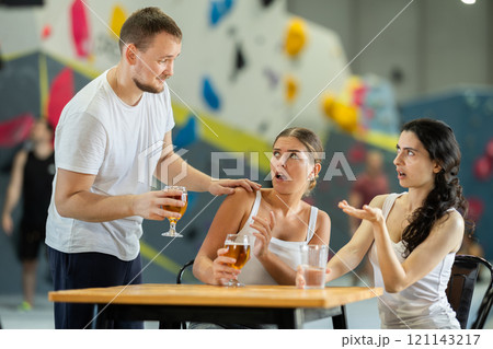 Man tries to talk to two angry women on climbing wall 121143217