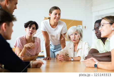 Young girl participating in Spanish language speaking club with group of people of different ages Young girl participating in Spanish language speaking club with group of people of different ages 121143313
