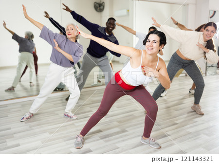 Group of adult people practices dance aerobics 121143321