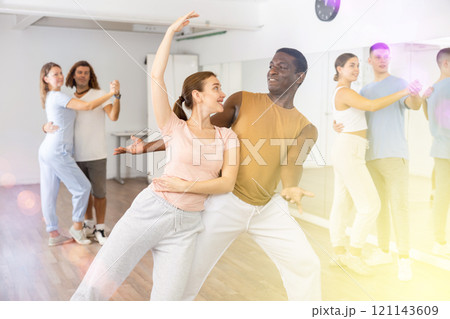 Woman and man practicing modern dance moves in pair during group class Woman and man practicing modern dance moves in pair during group class 121143609