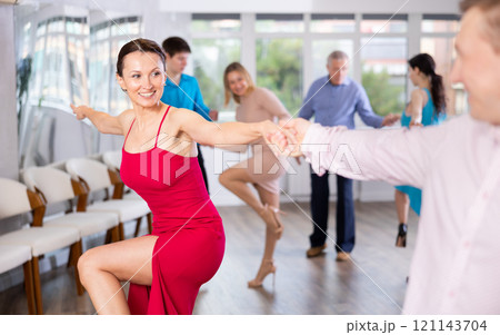Happy woman enjoying active dancing in pair in dance studio 121143704
