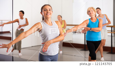 Latino girl dancing modern dance in studio with other dancers 121143705