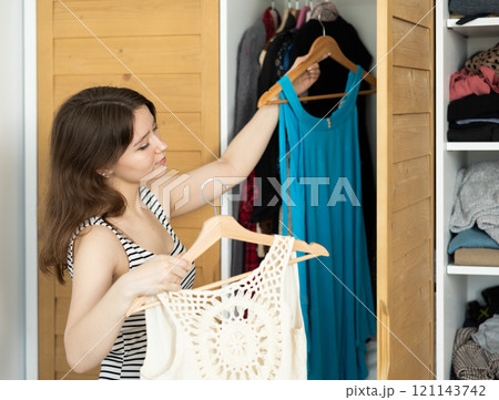 Young woman choosing which dress to wear 121143742