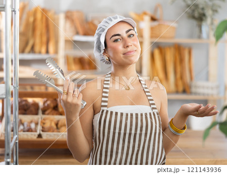 Young saleswoman holding a service clip ready to serve customers Young saleswoman holding a service clip ready to serve customers 121143936