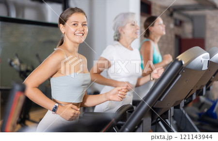 Girl in sportswear are running on treadmill Girl in sportswear are running on treadmill 121143944