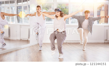Young girl practicing hip hop reject step in training hall 121144151